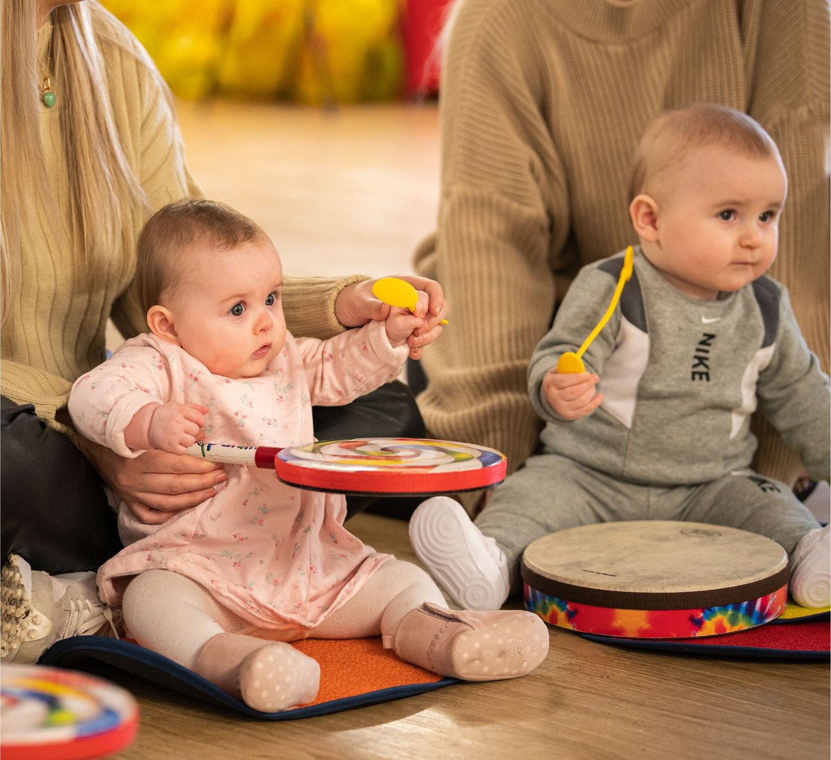 Babies exploring a lollipop drum with a Rhythm Time teacher